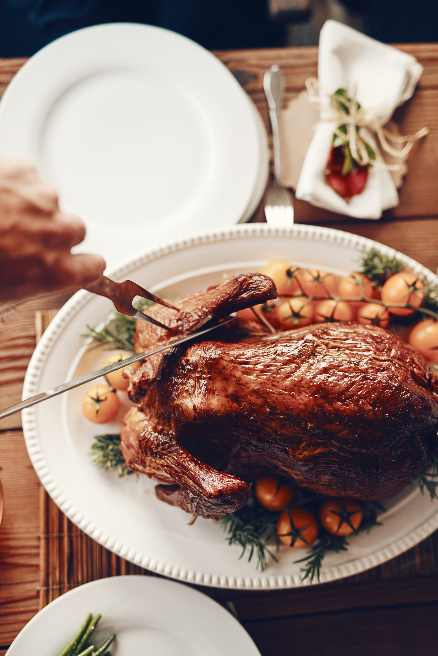 Person cutting chicken, food and table setting closeup for Christmas or Thanksgiving meal, dinner and party to celebrate. Celebration, nutrition and feast overhead, holiday with meat and vegetables